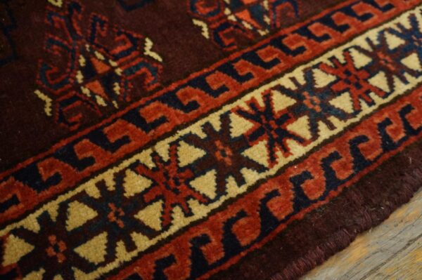 Close-up of the intricate border design on a deep red and brown rug by rugs on net. By rugs on net