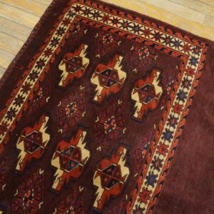Close-up of a dark red tribal rug with geometric motifs on a light wood floor by Rugs On Net