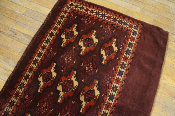 Close-up of a dark red tribal rug with geometric motifs on a light wood floor by rugs on net
