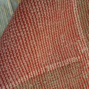 Faded pink rug with green border.