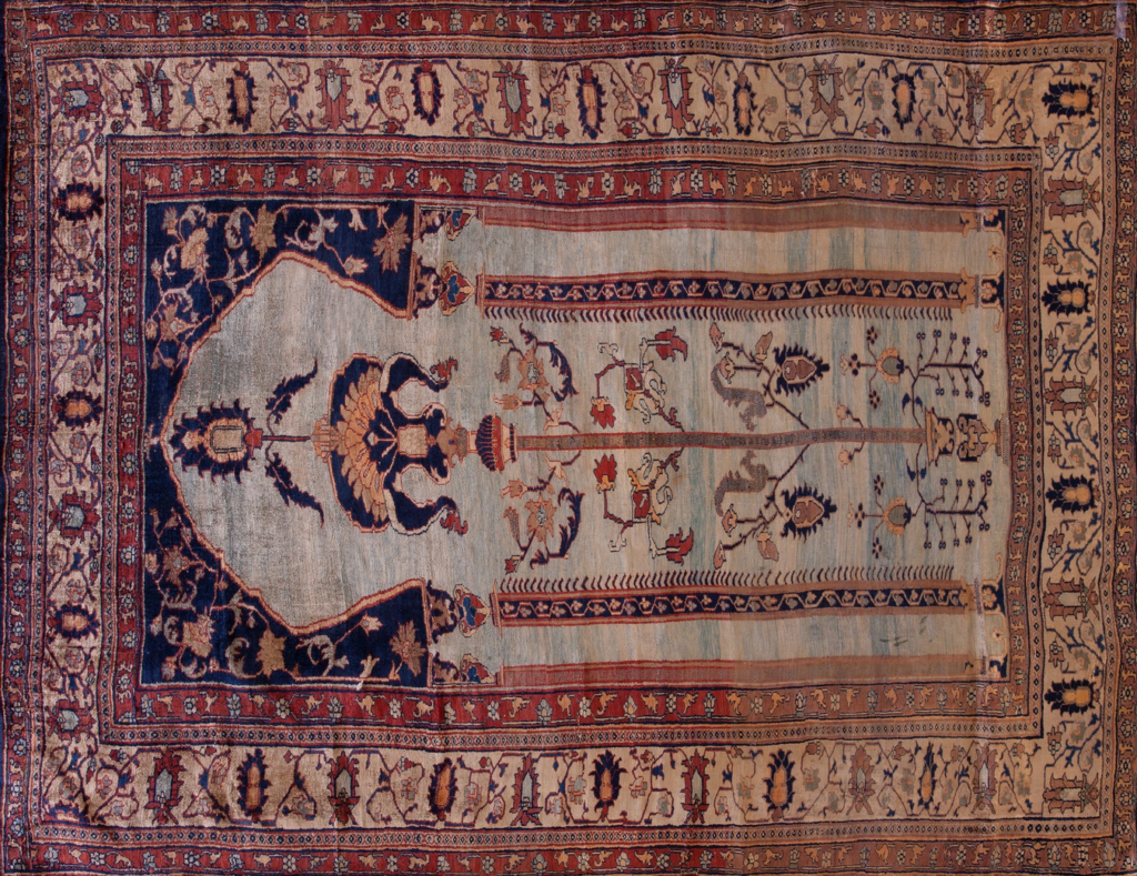 Antique prayer rug with a blue and cream mihrab featuring floral tree motifs and a terracotta patterned border by rugs on net