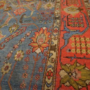 Close-up of a blue field rug with red border details, featuring floral and geometric motifs, by Rugs On Net