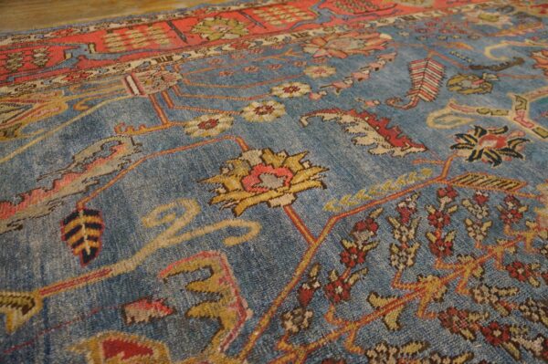 Close-up of a blue field rug with red and yellow floral motifs, by rugs on net