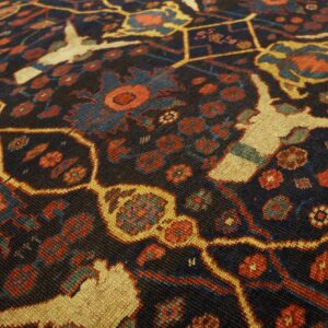 Close-up of a dark field rug with geometric patterns and stylized animal figures in red, blue, and cream, by Rugs On Net