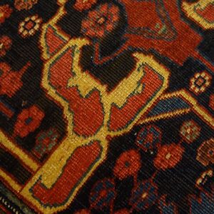Close-up of a detailed, dark field rug pattern featuring red and gold geometric motifs by Rugs On Net