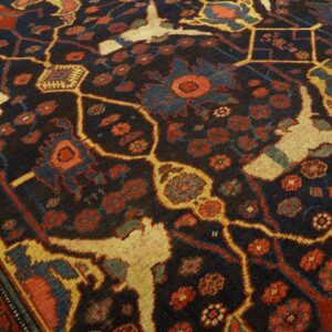 Close-up of a dark field rug with abstract floral and stylized animal motifs in red, blue, and cream, by Rugs On Net. by Rugs On Net