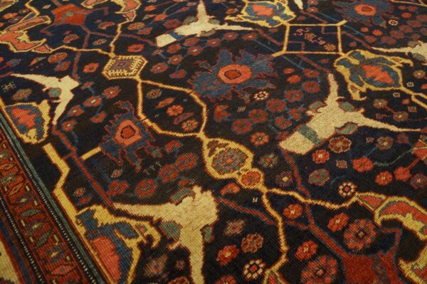 Close-up of a dark field rug with abstract floral and stylized animal motifs in red, blue, and cream, by rugs on net. By rugs on net