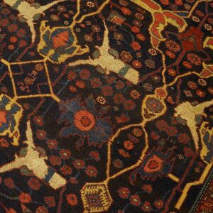 Close-up detail of a dark field rug with geometric and floral motifs in red, gold, and blue by Rugs On Net