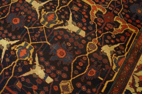 Close-up detail of a dark field rug with geometric and floral motifs in red, gold, and blue by rugs on net