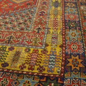 Close-up of a vibrant, richly patterned Oriental rug featuring red, yellow, and blue geometric motifs by Rugs On Net. by Rugs On Net
