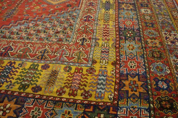 Close-up of a vibrant, richly patterned oriental rug featuring red, yellow, and blue geometric motifs by rugs on net. By rugs on net