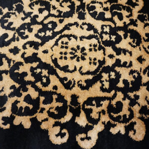 Black rug with intricate golden pattern