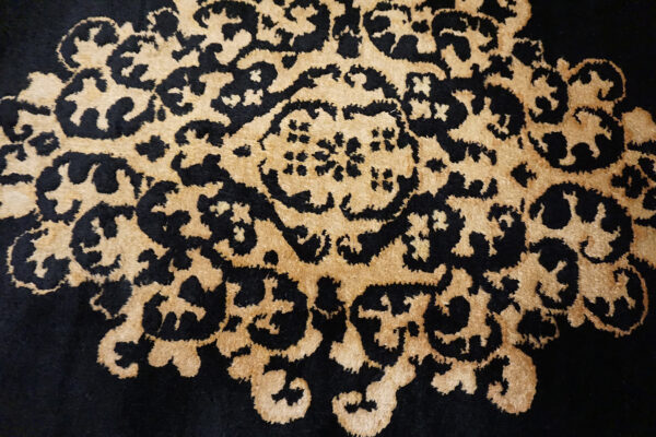 Black rug with intricate golden pattern