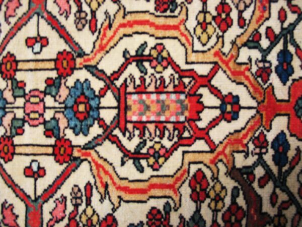 Close-up of intricate floral medallion detail on a light-colored rug by rugs on net