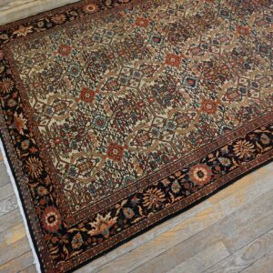 An overhead view of an intricately patterned Persian rug with cream, red, and blue accents on a distressed wooden floor by Rugs On Net. by Rugs On Net