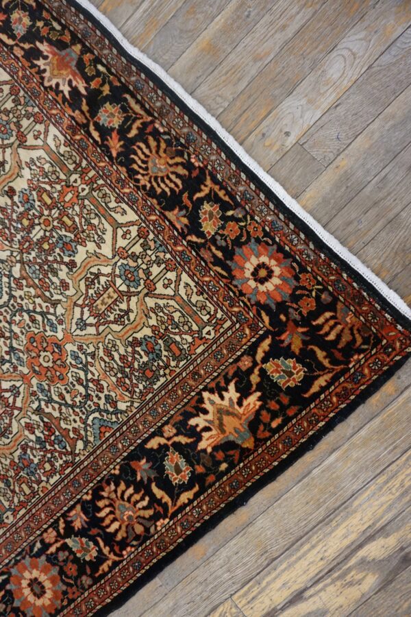 Corner detail of a traditional persian rug with intricate floral patterns on a dark border, by rugs on net. By rugs on net