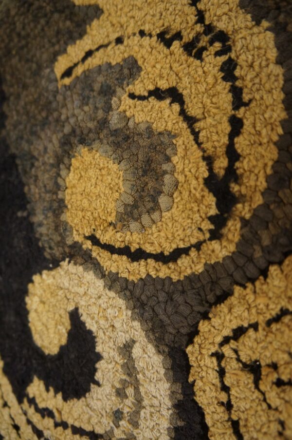 Close-up texture of a gold and black patterned rug by rugs on net