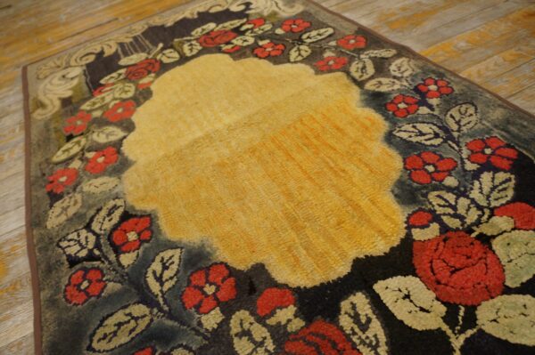 Close-up of a floral rug with a central yellow area and red flowers on a dark border by rugs on net