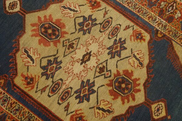 Close-up of a traditional rug pattern with beige field and blue accents by rugs on net. By rugs on net