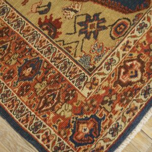Close-up of the corner of a richly patterned rug featuring red, blue, and tan hues, by Rugs On Net. by Rugs On Net