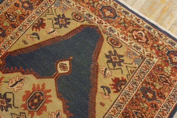 Close-up of a traditional rug showing dark blue field, tan accents, and intricate red border designs by rugs on net. By rugs on net