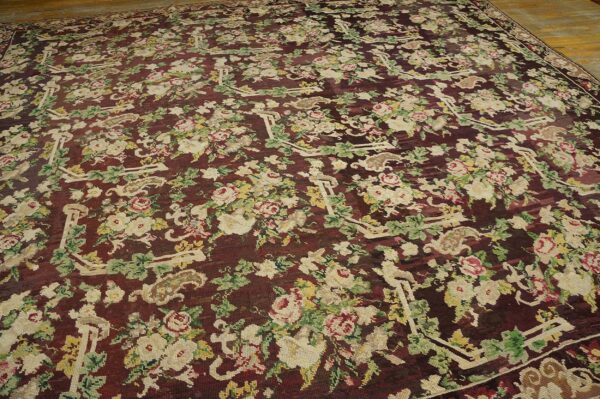 Close-up of a dark burgundy rug featuring an all-over floral pattern with cream and pink roses and green foliage, by rugs on net