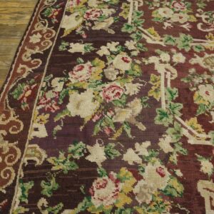 Close-up of a dark aubergine floral needlepoint rug on wood flooring by Rugs On Net
