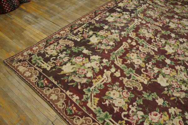 Close-up of a richly colored floral rug with a dark red field and cream roses, by rugs on net