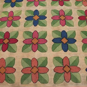 Close-up of a hooked rug featuring a repeating floral pattern with alternating red and blue flowers on a beige ground, by Rugs On Net. by Rugs On Net