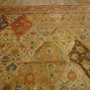 A richly patterned, antique-style rug featuring geometric and floral motifs in muted golds, reds, and blues on a wooden floor by Rugs On Net. by Rugs On Net