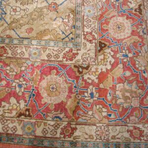 Close-up of a corner detail showing the intricate red, beige, and blue pattern of the Oriental Rug by Rugs On Net. by Rugs On Net