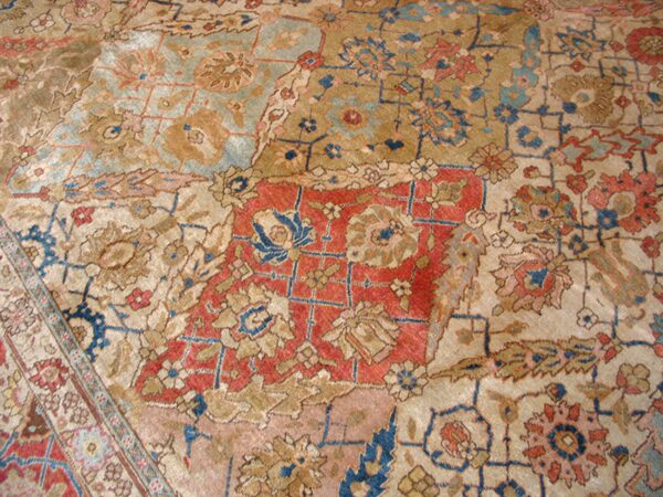 Close-up of faded, antique rug with geometric and floral patterns in muted reds, blues, and tans, by rugs on net