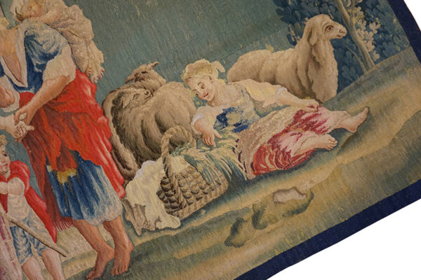Detail of a pastoral tapestry showing figures and sheep by rugs on net