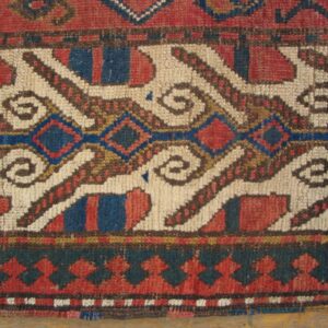 Close-up of a tribal rug pattern featuring white, red, and blue geometric shapes, by Rugs On Net