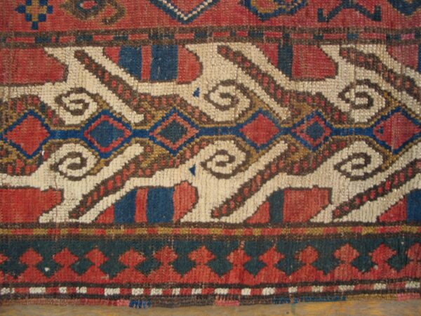 Close-up of a tribal rug pattern featuring white, red, and blue geometric shapes, by rugs on net