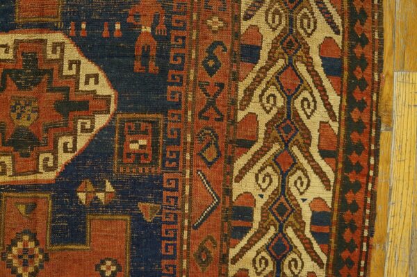 Close-up detail of an antique rug showing geometric patterns in red, navy blue, and cream, by rugs on net