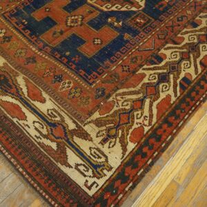Close-up corner detail of an antique rug featuring geometric patterns in red, navy blue, and cream, by Rugs On Net. by Rugs On Net