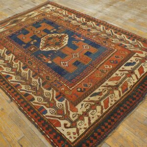 An antique rug with bold geometric patterns in red, blue, and cream on a wooden floor by Rugs On Net. by Rugs On Net