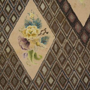 Close-up of a hooked rug featuring a central floral medallion surrounded by a brown diamond lattice pattern, by Rugs On Net. by Rugs On Net