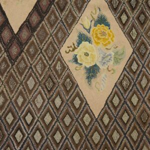 Close-up of a hooked rug featuring brown diamond patterns and a central beige medallion with yellow roses by Rugs On Net. by Rugs On Net