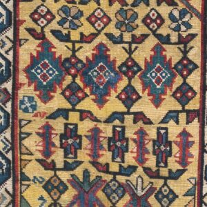 Close-up of an antique rug with geometric motifs on a gold field by Rugs On Net