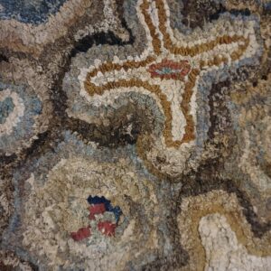 Close-up texture of a hooked rug featuring abstract brown, blue, and cream shapes, by Rugs On Net