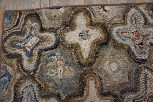 Close-up of a textured, multi-colored hooked rug featuring abstract, swirling patterns in earth tones and blues by rugs on net