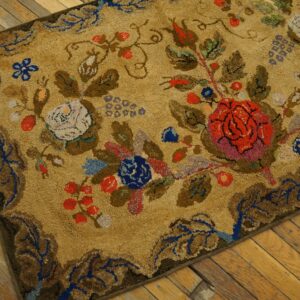 Close-up view of the textured, tan background of the Antique Arts and Crafts Floral Rug, showing detailed red, blue, and white flowers and foliage on a wooden floor by Rugs On Net. by Rugs On Net