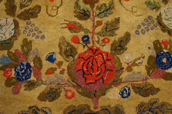 Close-up texture of the antique hooked rug, floral pattern, showing the central red rose design and looped wool texture by rugs on net