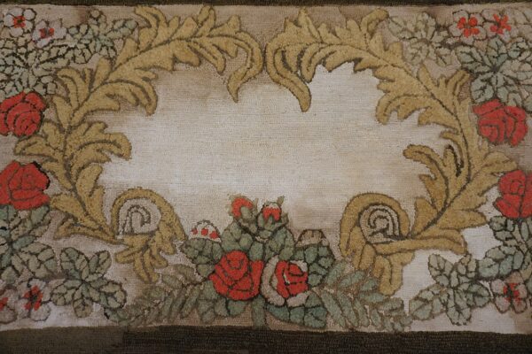 Close-up of a hooked rug featuring red roses and gold acanthus leaves framing a light center, by rugs on net