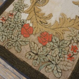 Close-up of a hooked rug featuring red roses and green foliage against a cream background, bordered in dark green, by Rugs On Net. by Rugs On Net
