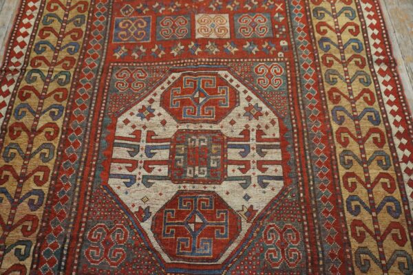 Close-up of a richly patterned, antique red and blue rug, featuring geometric medallions and border details by rugs on net. By rugs on net