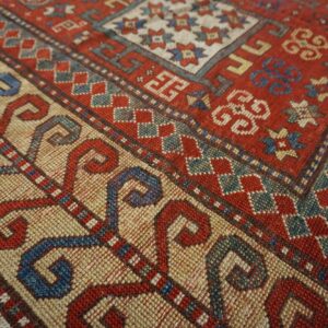 Close-up detail of the vibrant red and cream field with geometric borders of the Caucasian Rug by Rugs On Net. by Rugs On Net