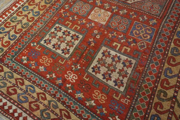 Close-up of a richly colored, geometric patterned rug featuring red, blue, and cream accents by rugs on net. By rugs on net